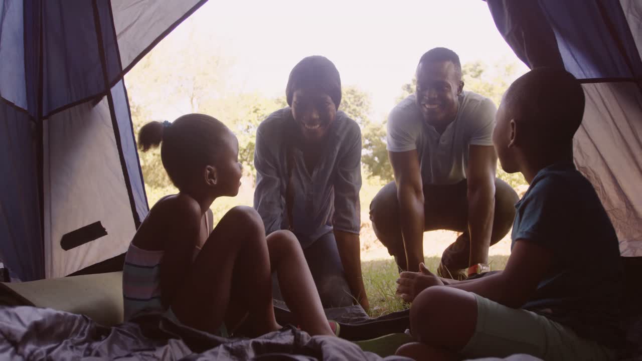 Familie diskuterer i et telt.