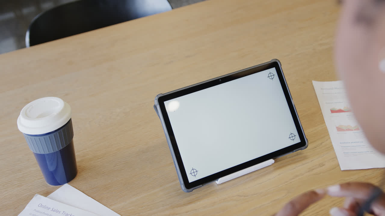 아프리카계 미국인 사업가 여성의 손이 카메라와 스로우모션으로 태블릿에서 비디오 통화를 하고 있습니다.