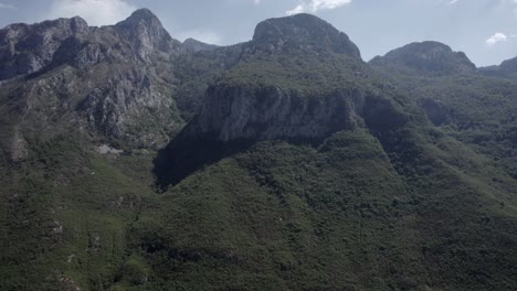 Side-shot-drone-video-"Reverse"-on-sh21,-albania,-with-the-mountains-in-front-as-the-main-shot