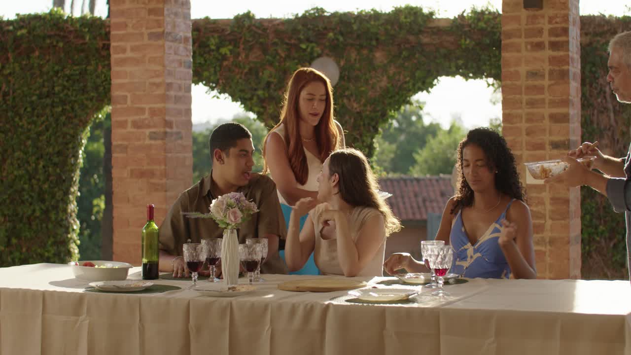 Family and friends enjoying a meal and conversation on a beautiful outdoor patio