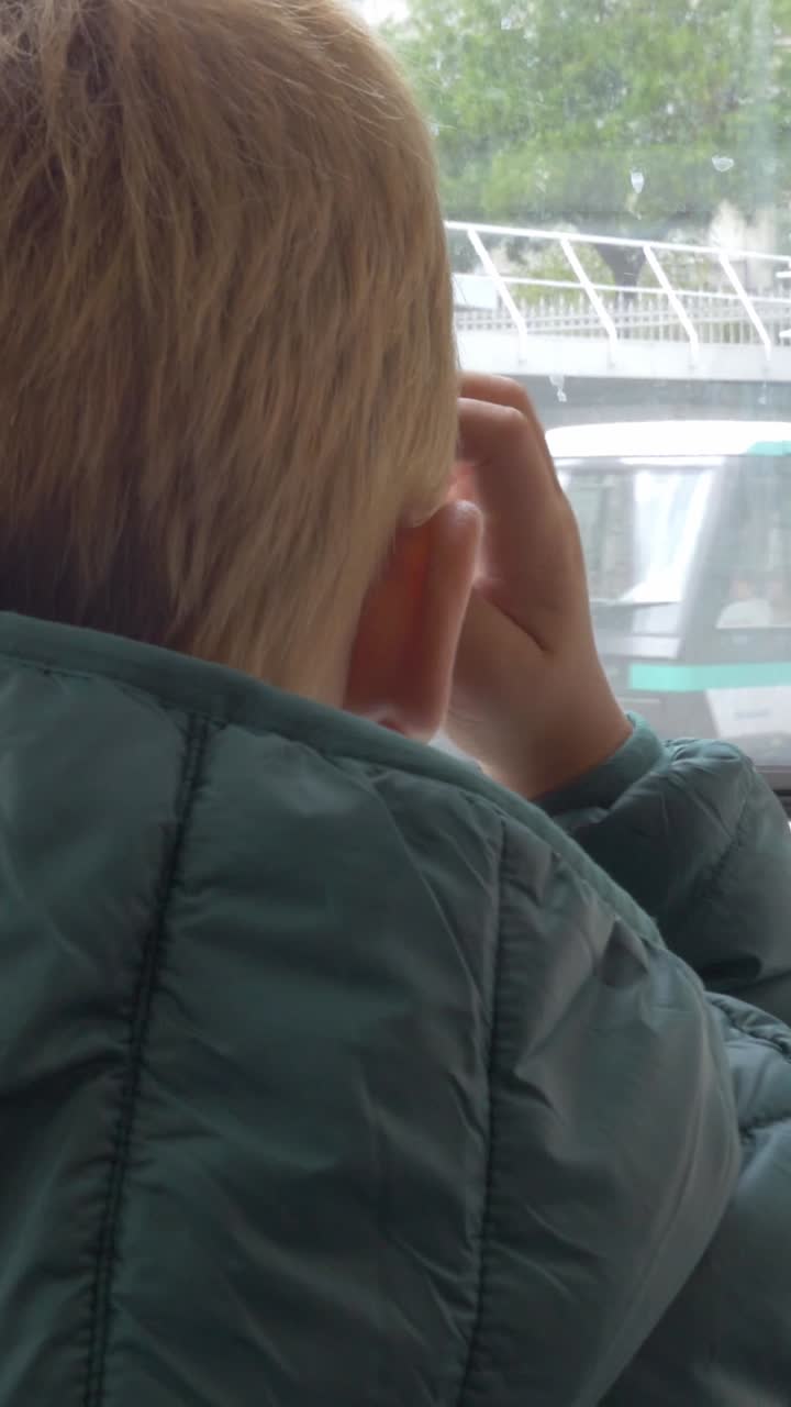 Back View of Child Looking Out Window During Travel