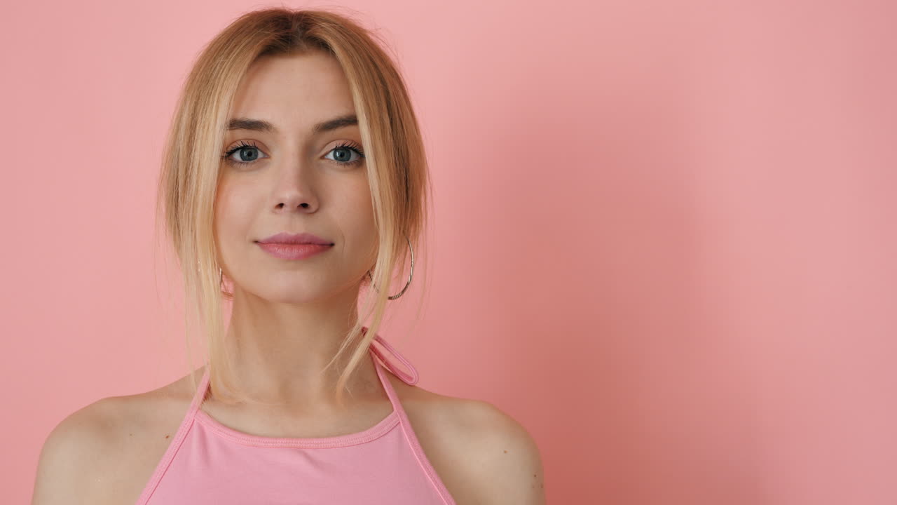 una hermosa mujer rubia mira a la cámara.