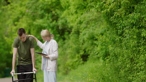 man with walker receiving assistance from a caregiver in a park