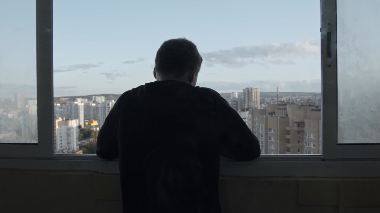 도시 풍경 에 있는 창문 밖 을 바라보는 사람