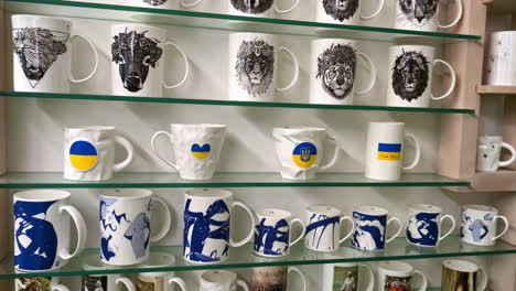 ceramic mugs on display featuring animal illustrations and ukrainian national symbols