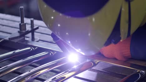 man wearing mask welding in a workshop. metal workers use manual labor. skilled welder. welder is welding the stainless steel pipes in the factory. welder industrial part in factory.