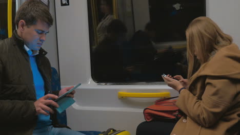 passengers of stockholm subway with gadgets