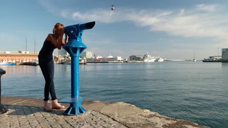 una joven asiática está mirando a través de un visor de torres y parece que no puede encontrar lo que está buscando