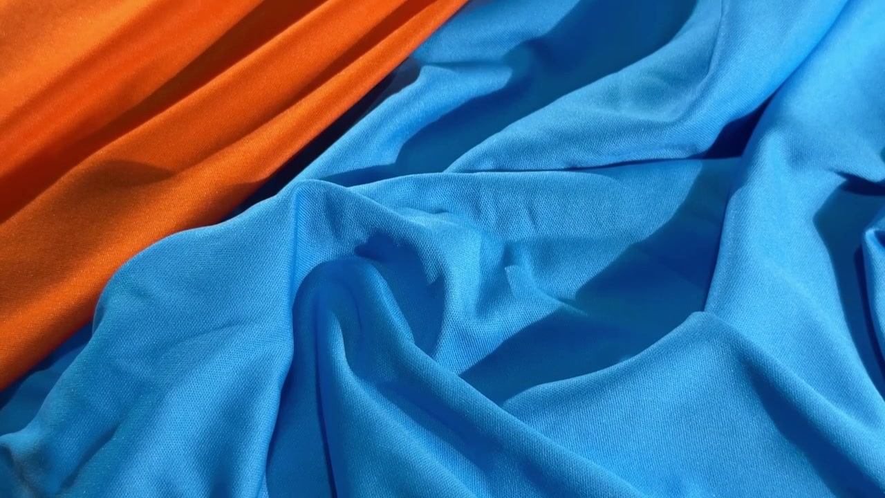 Primo piano di drappeggi in tessuto liscio blu e arancione