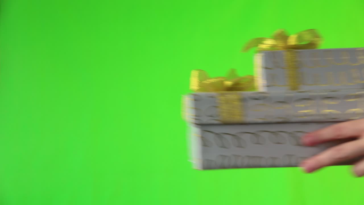 manos femeninas y cajas de regalos en el fondo verde