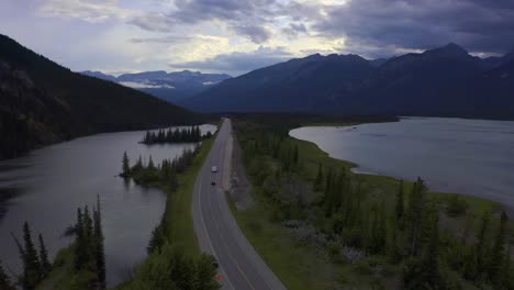 Dämmerung-Sommer-Luftaufnahme-Fall-über-Die-Autobahn-Buckelstraße-Innerhalb-Des-Bergtals,-Das-Seen-Trennt,-Sümpfe-Einige-Klare-Himmel,-Teilweise-Wolken-Mit-Wohnmobilreisenden-Aus-Der-Vogelperspektive,-üppige-Grüne-Strände-2-2