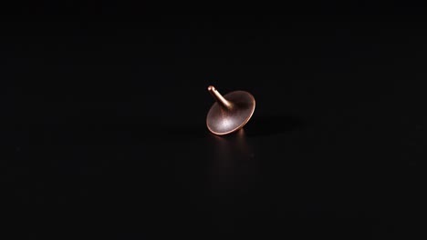 copper tops spinning on a dark surface