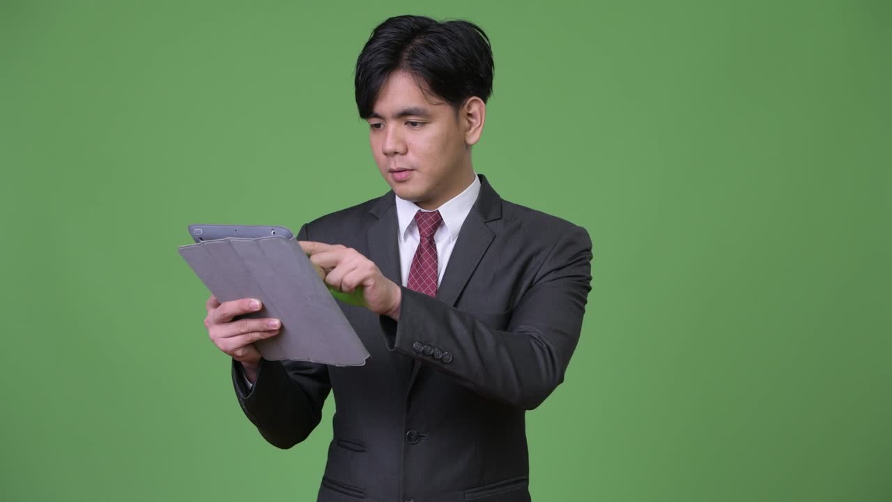 joven empresario asiático guapo usando una tableta digital
