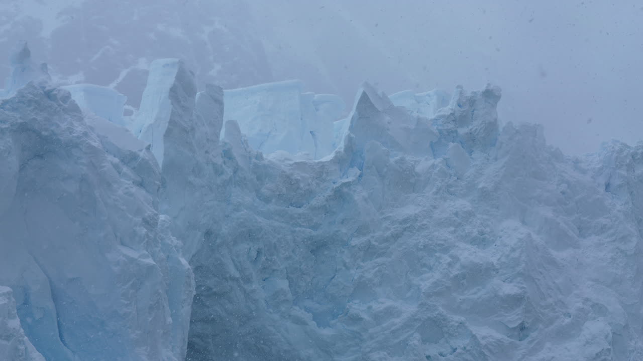 Panorama di ghiacciaio, massiccia formazione di ghiaccio sulla costa dell'Antartide in una giornata nevosa.