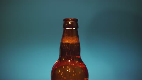 opening of beer bottle with bottle opener against