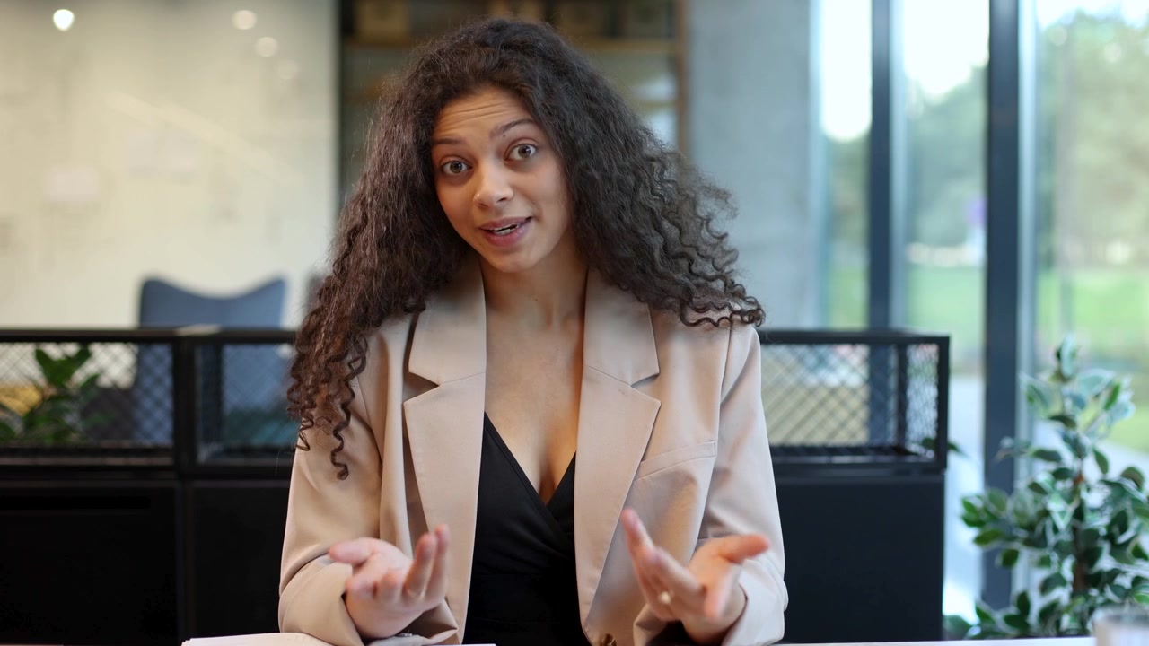 Young Professional Woman Speaking and Gesturing in Modern Office