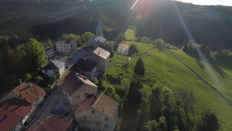 drone zoom in shot of a typical mountain village in france with sun flares