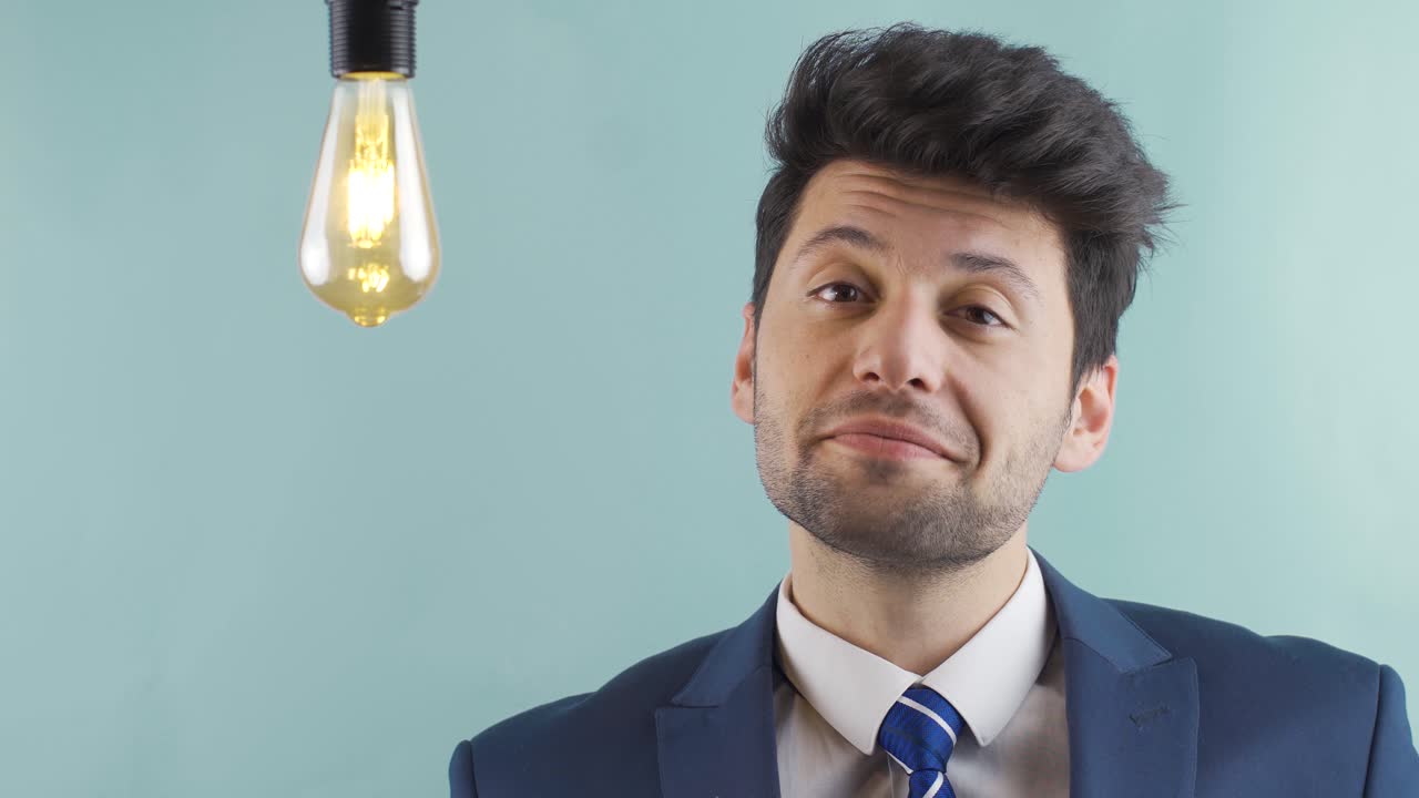 el hombre de negocios encuentra una nueva idea y al lado de ella se enciende la lámpara de la idea.