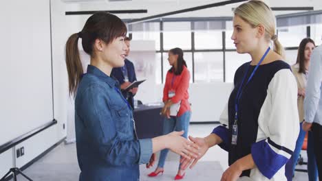 mujeres de negocios estrechando la mano en la oficina de la conferencia