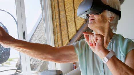 front view of caucasian senior woman using virtual reality headset in a comfortable home 4k