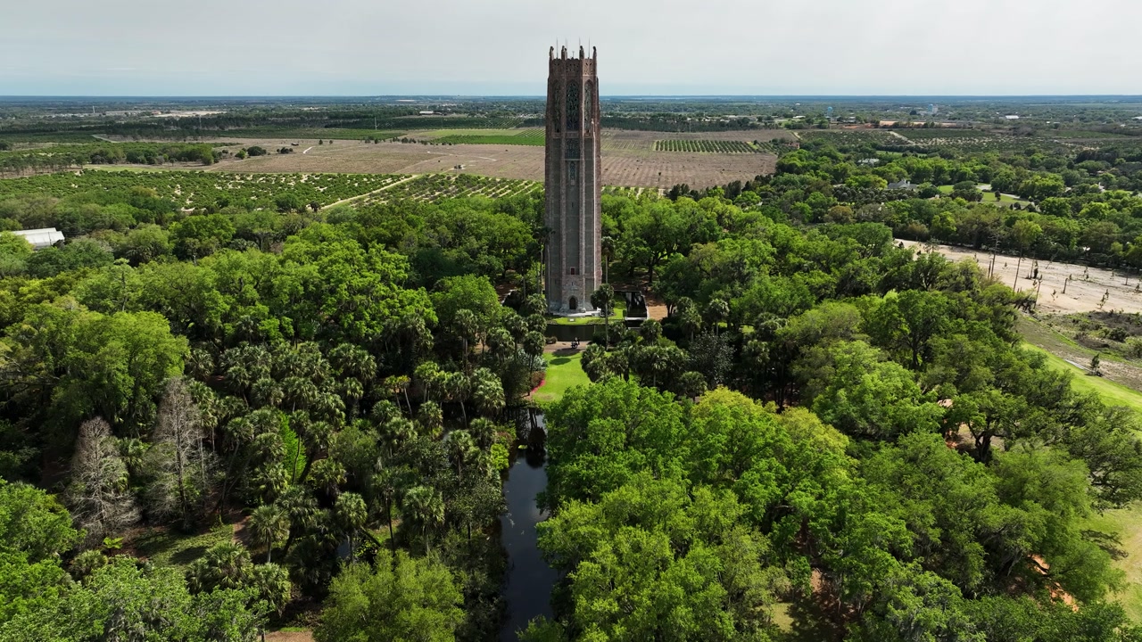 A smooth push-in shot towards Bok Tower over the pond in Lake Wales.