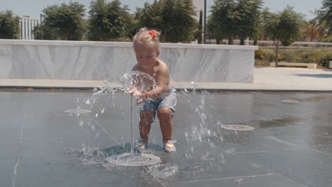 Niño-Pequeño-Jugando-Con-Chorro-De-Agua-De-Fuente-Callejera