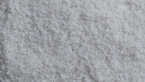 raw rice grains rotating pattern pile of cereal long seeds rice close up. white rice grains food background