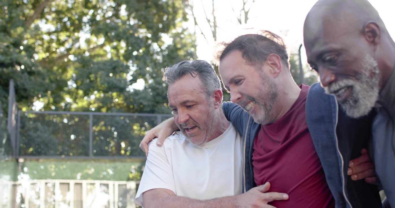 Diverse Männer helfen einem verletzten Spieler nach einer Verstauchung in der Nähe des Netzes und tragen ihn in Ausrüstung zum Zaun, um Hilfe zu holen.