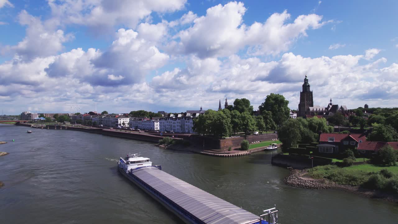 Aerial time lapse of transportation vessel on the river IJssel with floodplains in the background on a sunny day