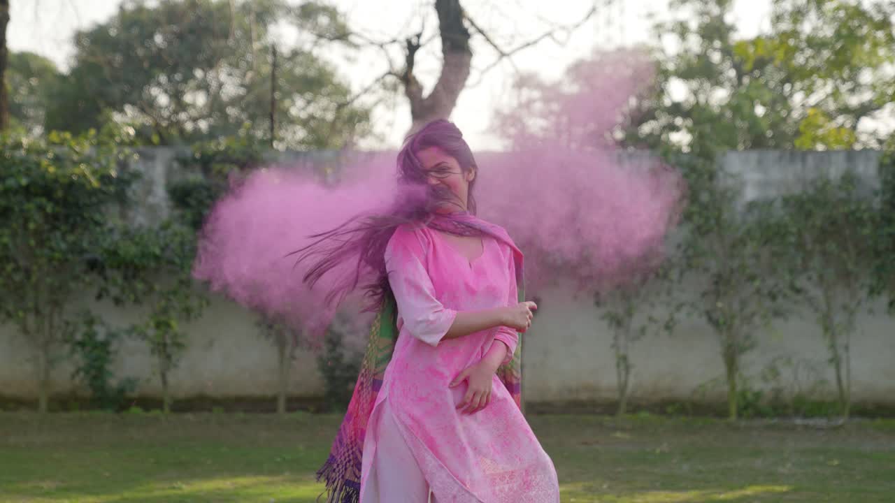 Ragazza indiana con i colori Holi nei capelli che scuote la testa