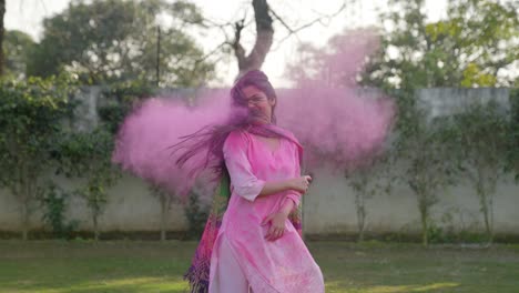 indian girl having holi colors in her hair and shaking her head