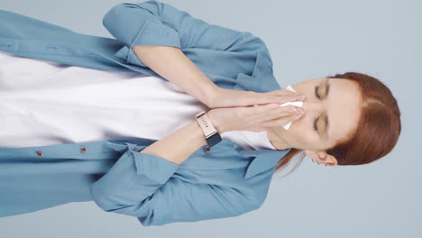 Vertical-video-of-Woman-covering-mouth-and-nose-while-sneezing.