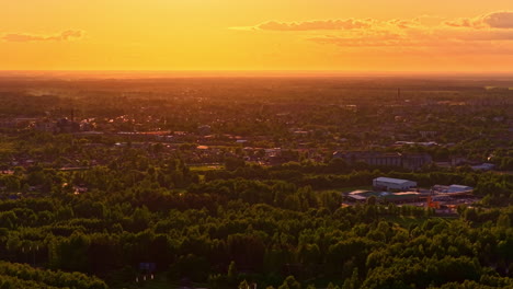 cityscape during golden sunset with glowing sky and houses between trees
