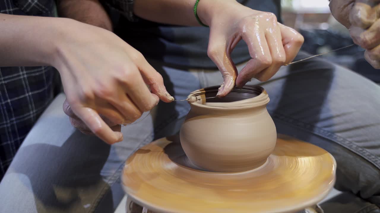 manos moldeando arcilla en una rueda de cerámica