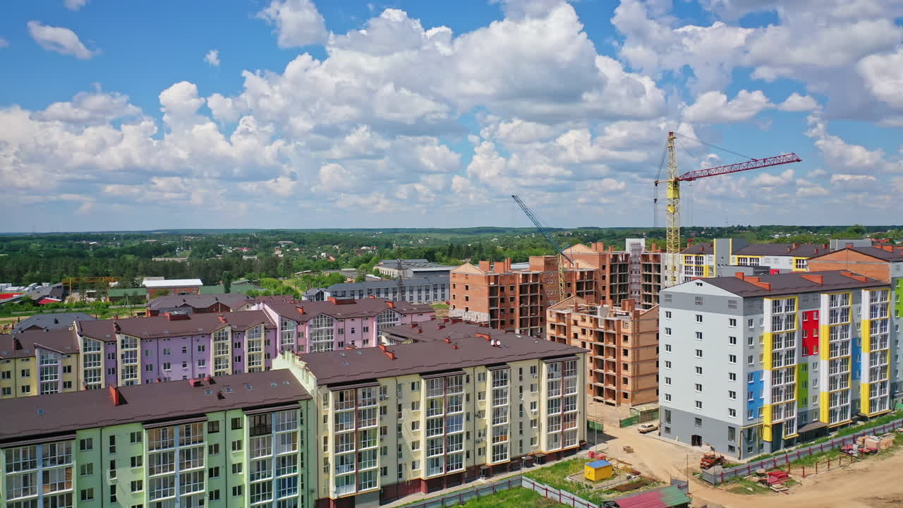 Construction of new residential district. Modern multi storey apartment buildings in construction site against blue sky. Tower crane build high rise buildings.