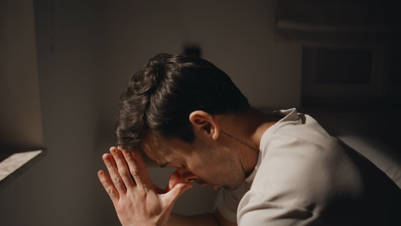 Despair grip man sitting in dark bedroom at night closeup. Guy showing stress