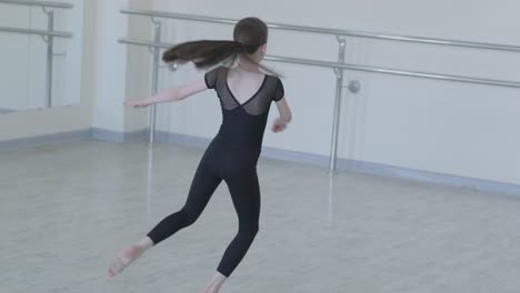 young ballerina practicing dance moves in studio