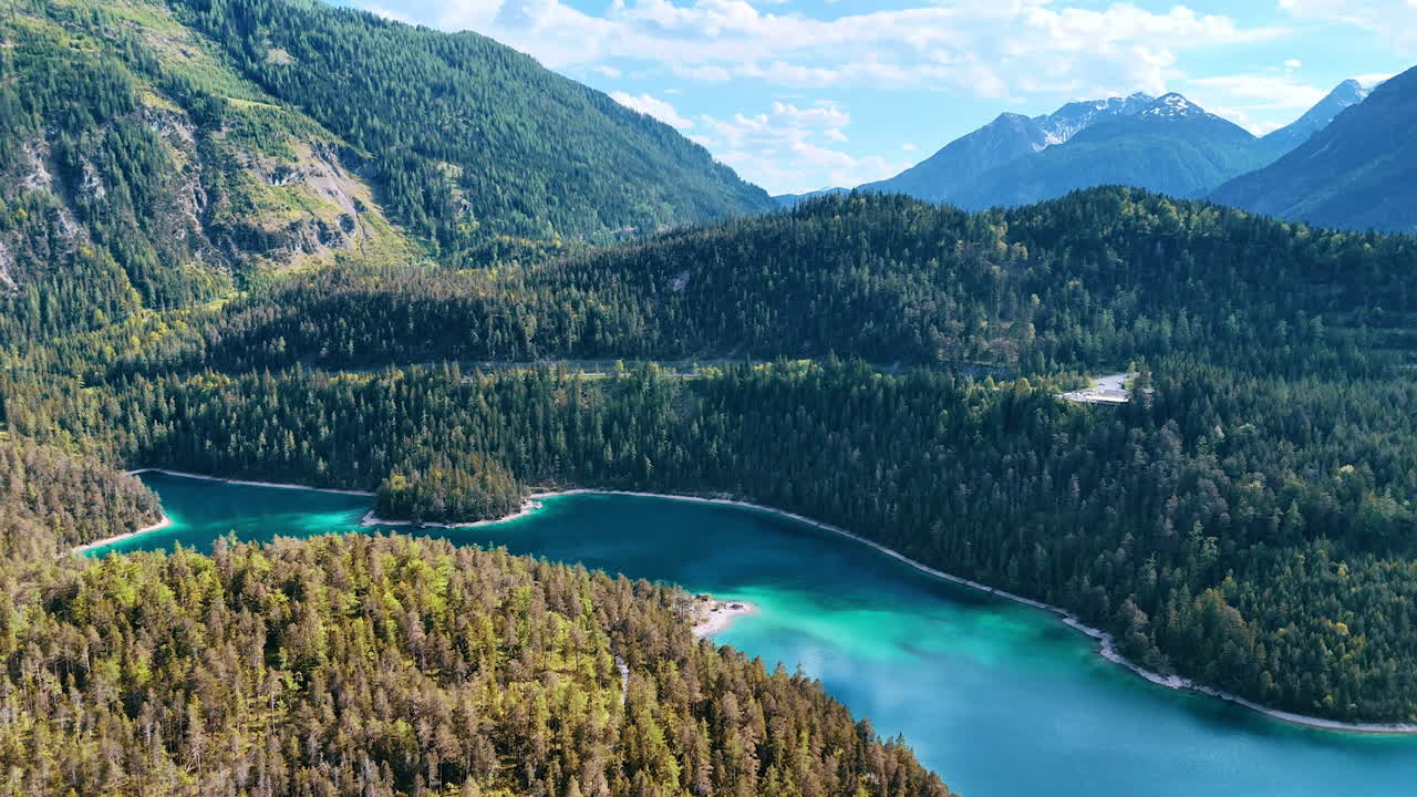 Jaw-dropping scenery of mountains covered with evergreen pine-tree forests. Top view of the lake situated among the wooded rocks.