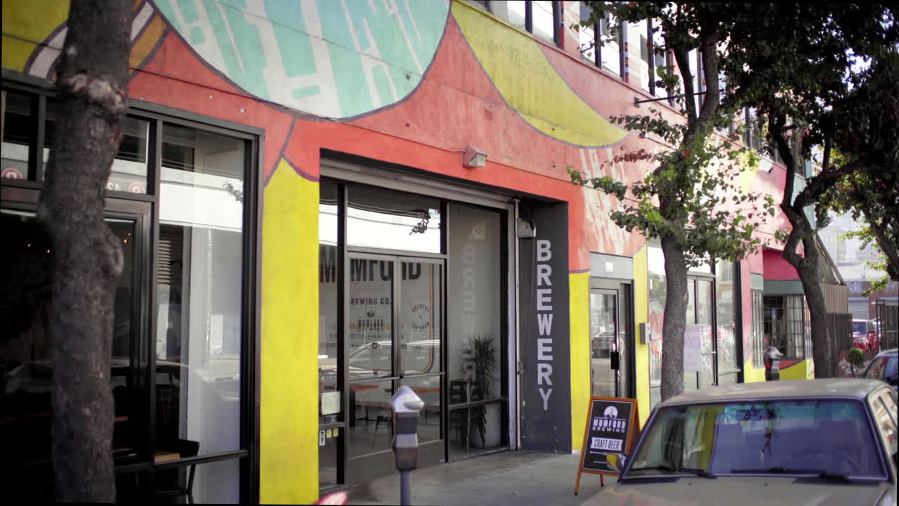 Vibrant Urban Brewery Storefront with Street Art and Tree