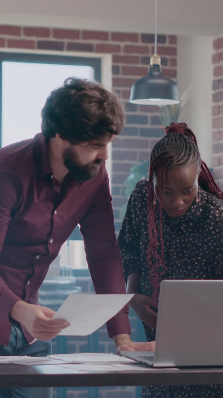 Two coworkers collaborate on a project in the office