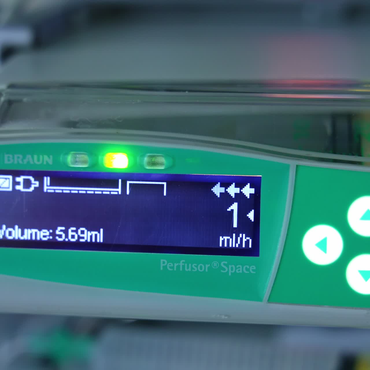 Perfusor syringe pump used at surgical operation. Close up. Little blue sensor screen is on at the display of equipment. Blurred backdrop