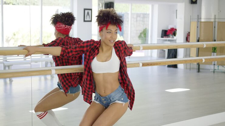 Attractive female dance student uses hand bar