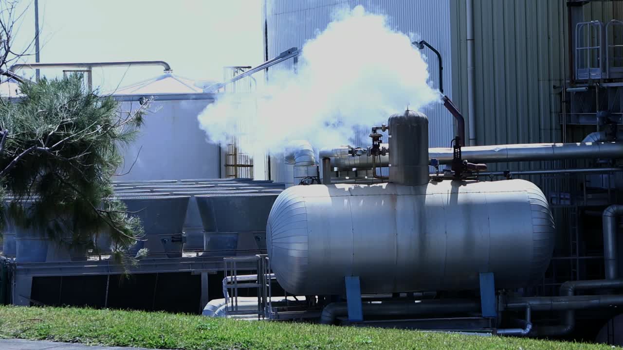 Large Industrial steam blowing tank procedure power plant inserted in a natural green enviroment