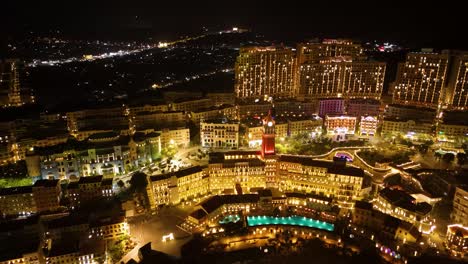 aerial view of phu quoc’s sunset town at night, showcasing glowing buildings, illuminated streets, vibrant architecture, luxury resorts, and a lively mediterranean-inspired cityscape. vietnam.