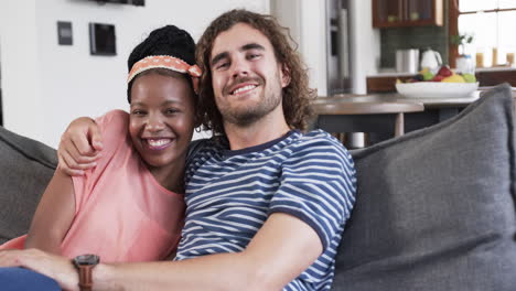 diverse couple enjoys a cozy moment on a couch at home