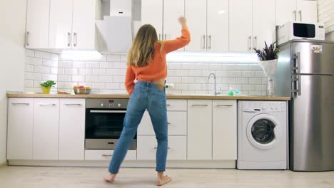 young happy woman dancing in kitchen and having some fun, slow motion