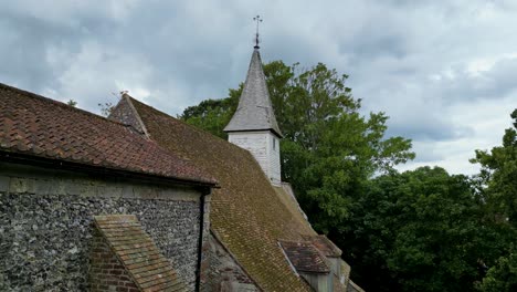 a rising pedestal shot of all saints church in west stourmouth, focused on the steeple