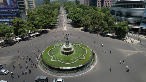 orbital-drone-shot-of-fuente-de-la-diana-cazadora-while-cyclists-exercise-in-mexico-city-during-Sunday