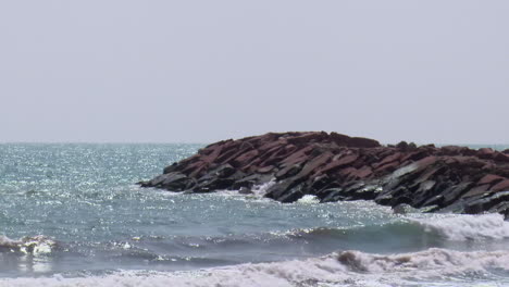 ocean waves crashing on rocks at the shore