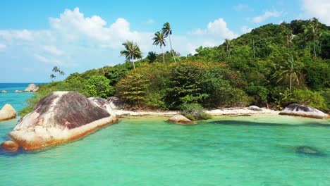 peaceful secret exotic beach hidden by big limestone cliffs washed by calm clear water of turquoise lagoon and palm trees in thailand